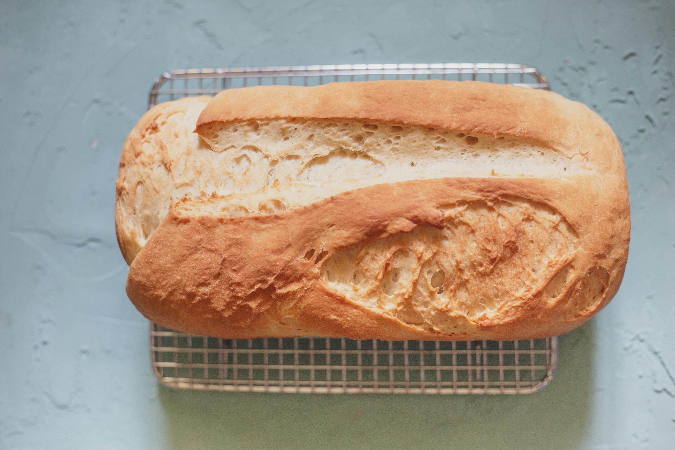 Golden brown homemade bread loaf cooling on a wire rack, ready to serve and enjoy.