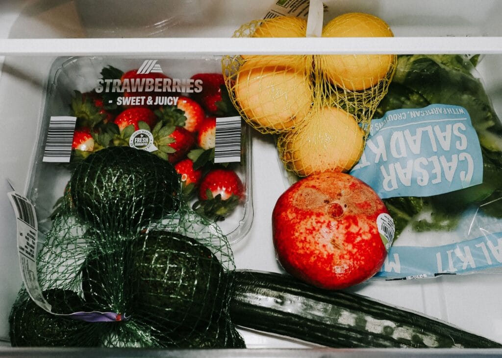 Fresh produce stored in a refrigerator crisper drawer, an example of the high-humidity storage cucumbers also need