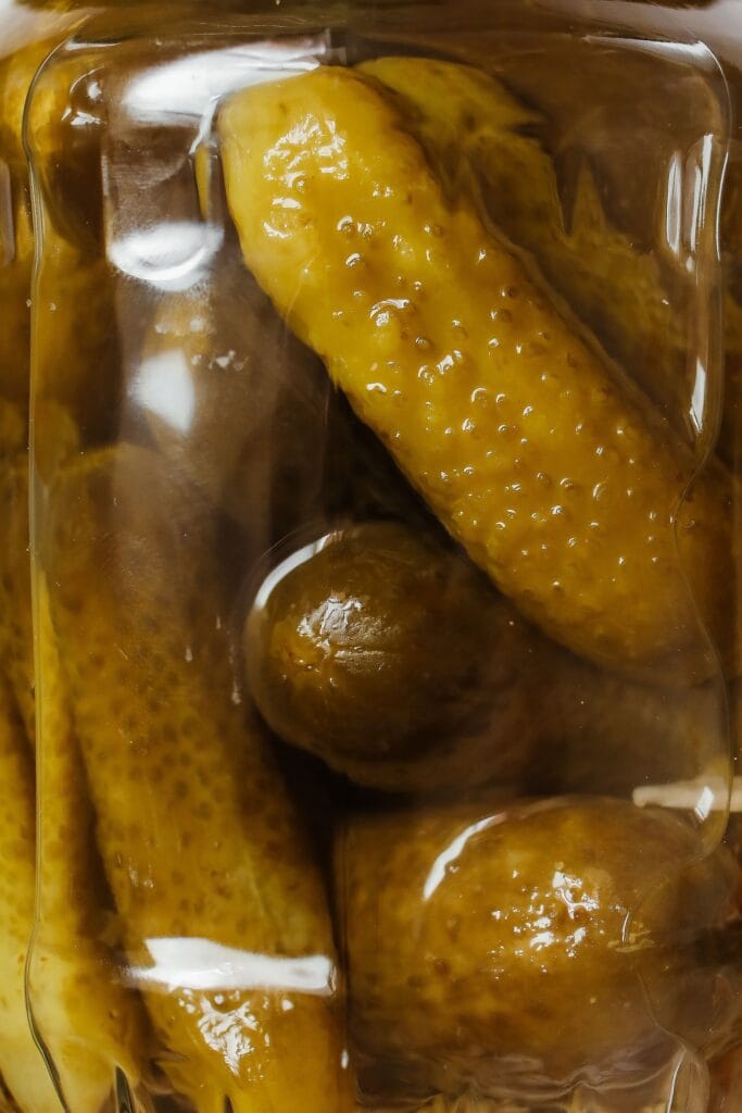 Refrigerator pickling method shown in a glass jar of brined vegetables
